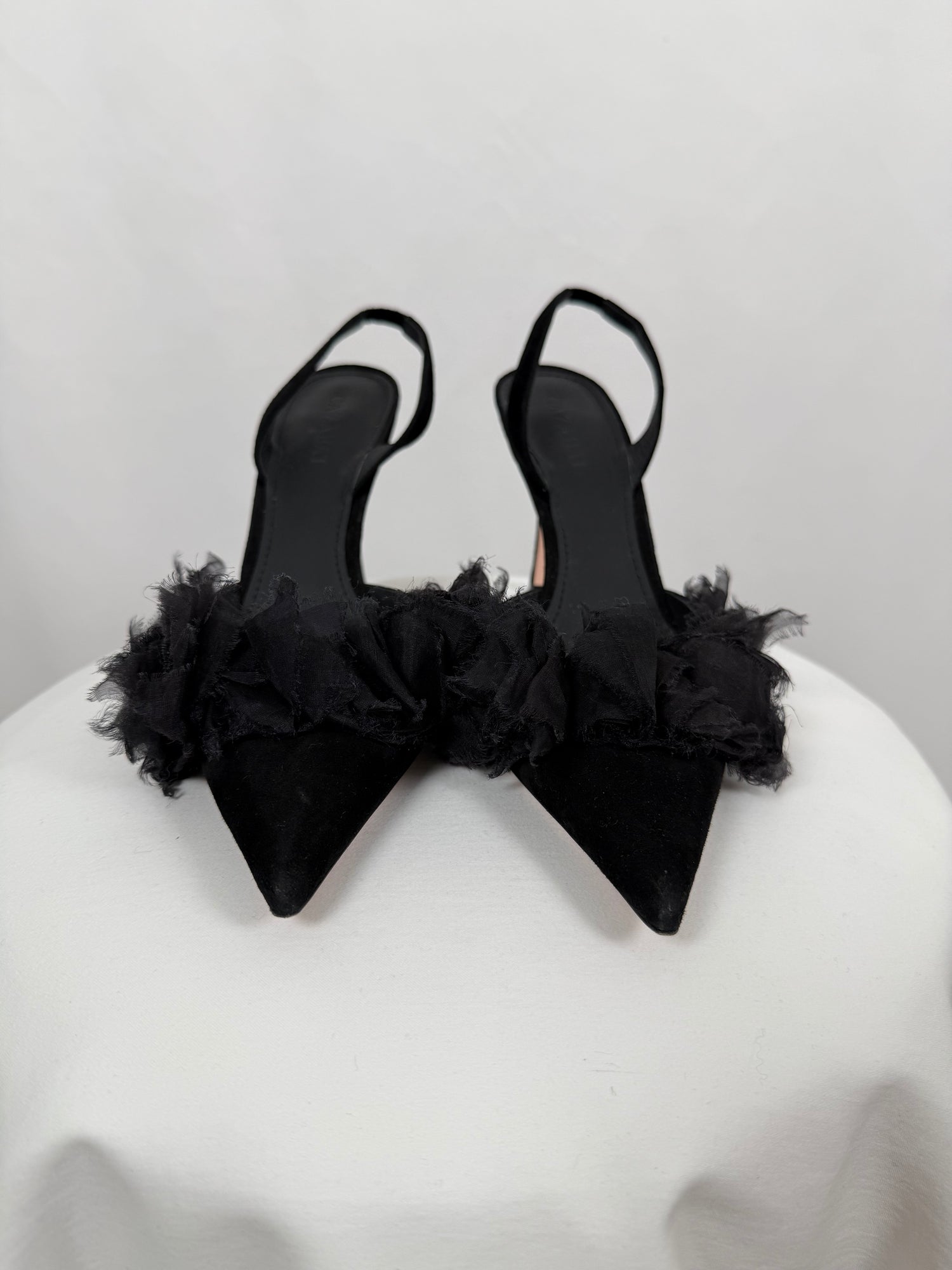 Black ruffled pumps